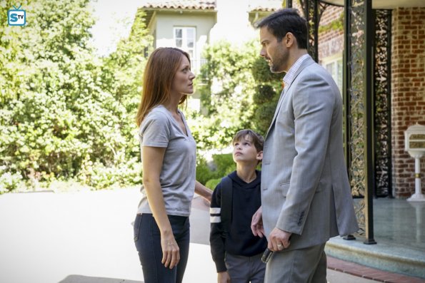 Elizabeth parle avec son mari et son fils devant chez eux