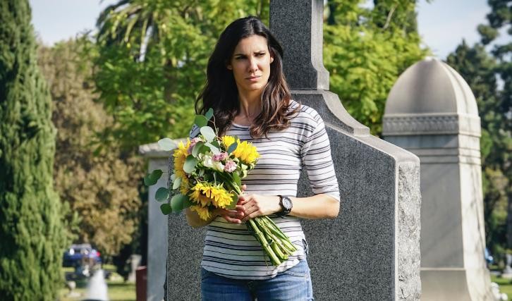 Kensi au cimetière va poser des fleurs sur une tombe
