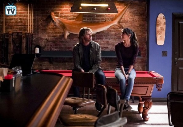 Deeks (Eric Christian Olsen) et Kensi (Daniela Ruah) observent la salle assis sur la table de billard