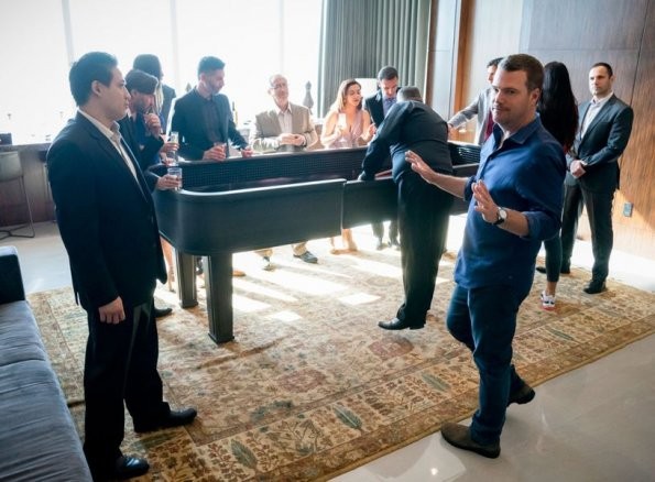 Callen joué par Chris O'Donnell lève les mains devant un homme dans une salle