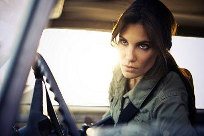 L'agent Blye joué par Daniela Ruah regarde en dehors du véhicule