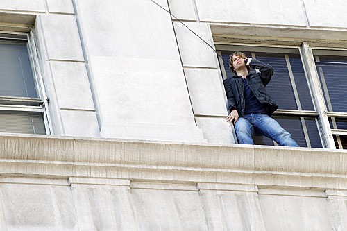 Deeks (Eric christian Olsen) au téléphone debout sur une fenêtre