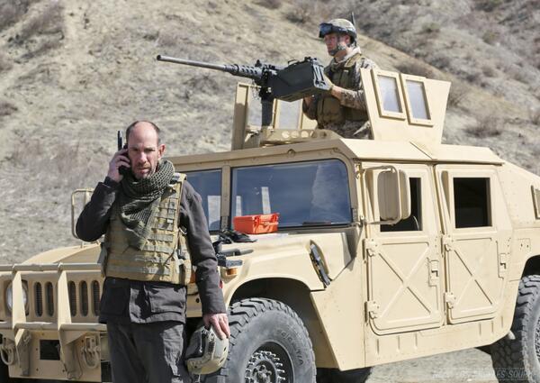 Le sous directeur Owen Granger  au téléphone devant un SUV en Afghanistan