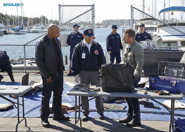 Un agent de sécurité du port regarde une mallette avec Sam et Callen